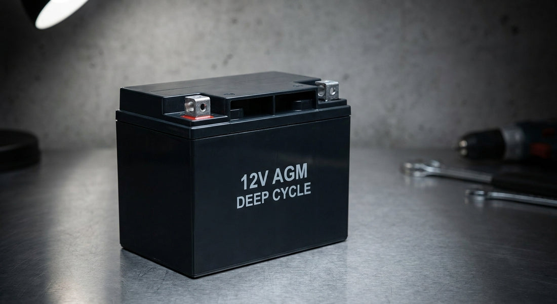 A close-up of a sealed AGM battery on an industrial workbench under studio lighting, highlighting its terminals and matte black casing.