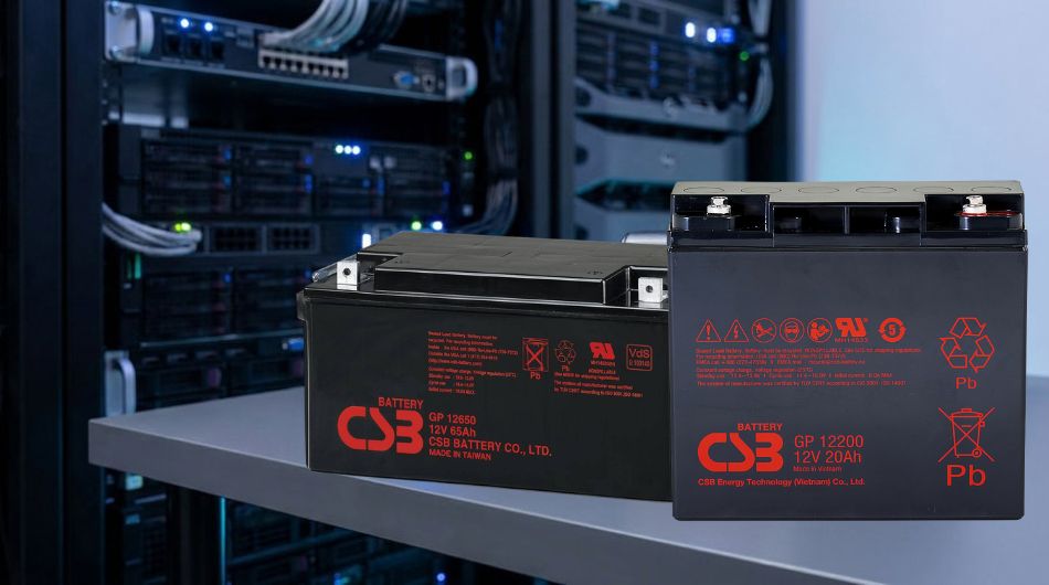 A professionally arranged selection of VRLA lead-acid batteries of different sizes displayed on a grey concrete surface under studio lighting.
