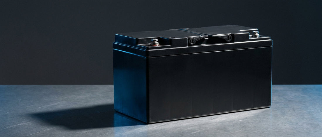 A sealed VRLA AGM battery photographed in professional studio lighting against a dark charcoal background, conveying industrial reliability and technical precision.